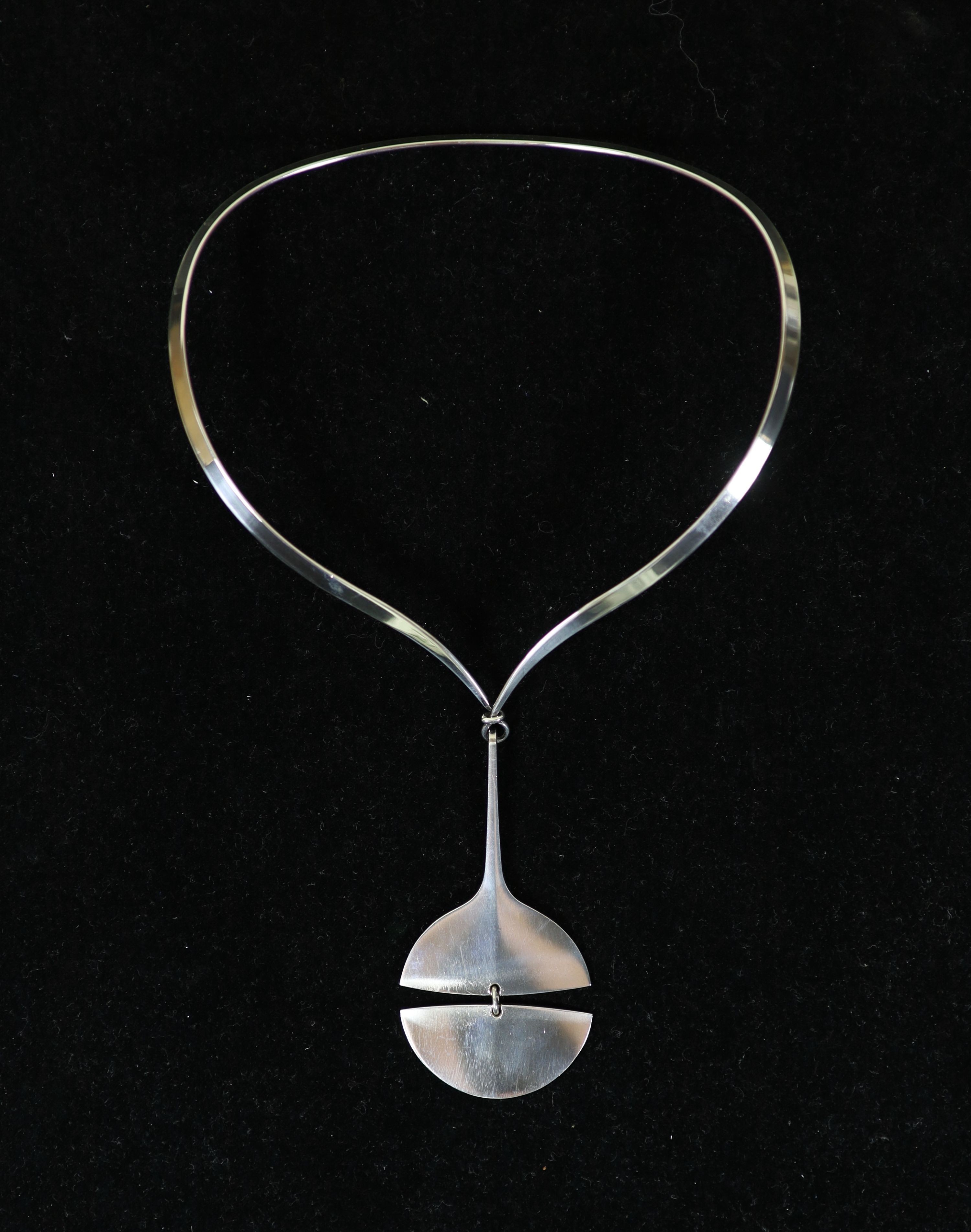 A Georg Jensen sterling silver drop pendant, no. 144, together with a Georg Jensen Torun sterling silver torque necklace, no. 169